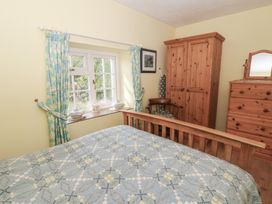 A bedroom with a bed and wardrobe at Llainorfa in Maenygroes near New Quay
