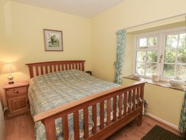 A bedroom with a bed and window at Llainorfa in Maenygroes near New Quay