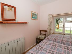 A bedroom with two beds and a window at Llainorfa in Maenygroes near New Quay