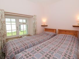 A bedroom with twin beds and a window at Llainorfa in Maenygroes near New Quay