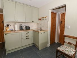 A kitchen with green cabinets and a sink at Llainorfa in Maenygroes near New Quay