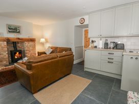 A living room with a sofa and fireplace at Llainorfa in Maenygroes near New Quay