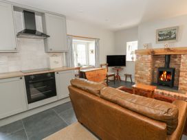 A kitchen with a fireplace and dining area at Llainorfa, Maenygroes near New Quay