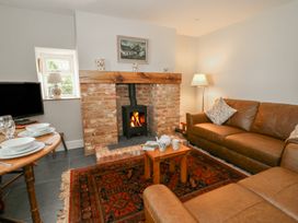A living room with a fireplace and sofa at Llainorfa near New Quay
