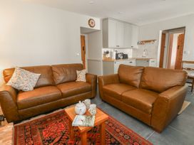 A living room with sofas and a table at Llainorfa in Maenygroes near New Quay