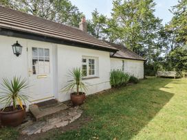An exterior view of a cottage with a door and potted plants at Llainorfa in Maenygroes near New Quay