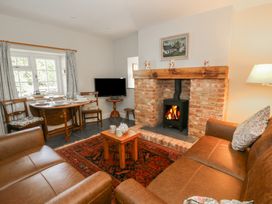 A living room with a fireplace and dining area at Llainorfa Maenygroes near New Quay