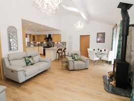A living room with a sofa and dining area at The Barn in Astwood Bank
