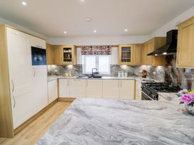 A kitchen with cabinets, sink, and stove at The Barn Astwood Bank