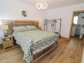 A bedroom with a bed and clothes rack at The Barn in Astwood Bank
