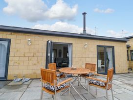 An outdoor patio with a table and chairs at The Barn in Astwood Bank