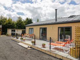 An outdoor patio area with tables and chairs at The Barn in Astwood Bank