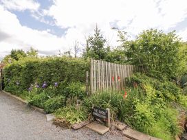 A garden with flowers and a sign at The Barn in Astwood Bank