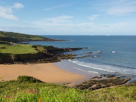 A coastline with a sandy beach rocks and greenery overlooking the sea at Caravan 7 in Plymouth