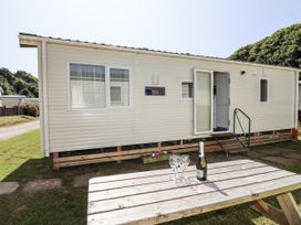 A caravan with a table and glasses outside at Caravan 7 in Plymouth