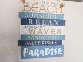 A decorative sign with beach-themed words at Caravan 7 in Plymouth