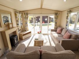 A living room with two sofas a coffee table and fireplace at The Meadows 45 in Tattershall