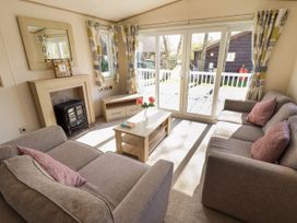 A living room with two sofas a coffee table and a fireplace at The Meadows 45 in Tattershall