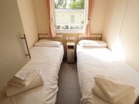 A bedroom with two single beds with white bedding and towels on each bed at The Meadows 45 in Tattershall