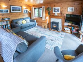 A living room with a sofa, coffee table, and bookshelf at Watendlath in Keswick