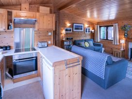 A living room with kitchen appliances and seating area at Watendlath in Keswick