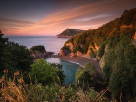 A view of a sandy beach surrounded by cliffs at 18 Manleigh Park in Combe Martin