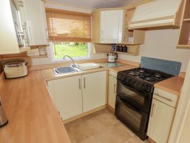 A kitchen with stove sink toaster and cabinets at Grandads Shack in Trevethin near Pontynewynydd