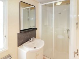 A bathroom with a sink cabinet mirror and a glass enclosed shower at Grandads Shack in Trevethin near Pontynewynydd
