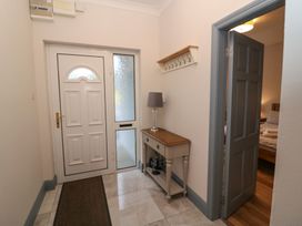 A hallway with a door, window, and console table at No 1 Lodge Wood, Kenmare, County Kerry