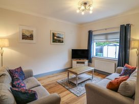 A living room with a television and seating at No 1 Lodge Wood, Kenmare, County Kerry