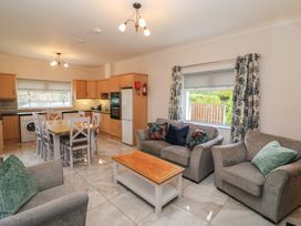 A living room with a kitchen area and dining table at No 1 Lodge Wood, Kenmare, County Kerry