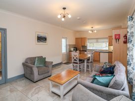 A living room with a sofa and dining area at No 1 Lodge Wood in Kenmare, County Kerry