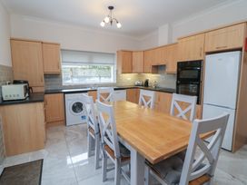 A kitchen with a dining table and appliances at No 1 Lodge Wood, Kenmare, County Kerry