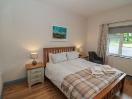 A bedroom with a bed and nightstand at No 1 Lodge Wood in Kenmare, County Kerry