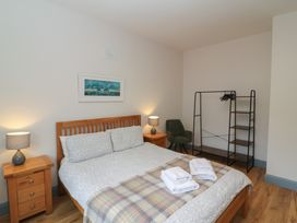 A bedroom with a bed and a wardrobe at No 1 Lodge Wood, Kenmare, County Kerry