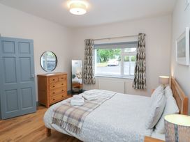 A bedroom with a bed and a dresser at No 1 Lodge Wood in Kenmare, County Kerry