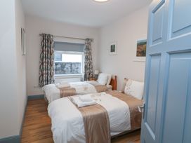 A bedroom with two beds and art on the walls at No 1 Lodge Wood, Kenmare, County Kerry