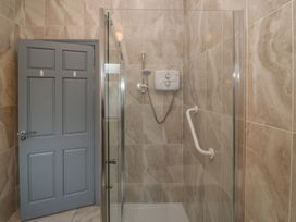 A shower stall with glass door and gray door at No 1 Lodge Wood, Kenmare, County Kerry