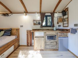 A kitchen with a sink and cabinets at Tanglewood Shepherds Hut in Welshpool