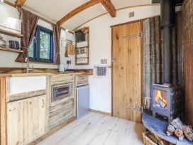 A kitchen with stove and refrigerator in Tanglewood Shepherds Hut Welshpool