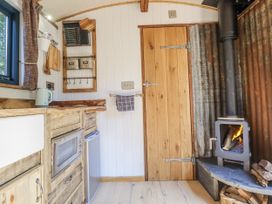 A kitchen with a sink, stove, and refrigerator at Tanglewood Shepherds Hut Welshpool