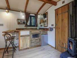 A kitchen with wooden cabinets and appliances at Tanglewood Shepherds Hut in Welshpool