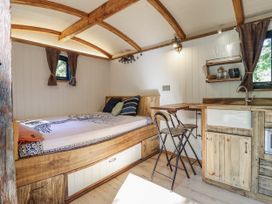 A studio room with a bed and kitchenette at Tanglewood Shepherds Hut in Welshpool