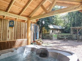 An outdoor seating area with a hot tub at Tanglewood Shepherds Hut Welshpool