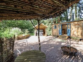 An outdoor seating area with a table and chairs at Tanglewood Shepherds Hut in Welshpool