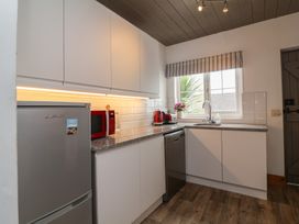 A kitchen with appliances and a window at Cobblestone Cottage in Bude