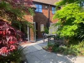 A garden with a glass table and chairs at Old Town Cottage in Stratford-Upon-Avon
