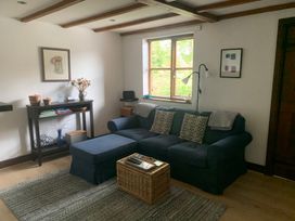 A living room with a sofa, coffee table, and lamp at Old Town Cottage in Stratford-Upon-Avon