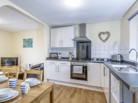 A kitchen with a table and chairs at Chalet 2 at Landscove Holiday Park in Brixham