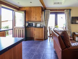 A kitchen and dining area with wooden cabinets a brown leather sofa and glass doors at Dolphin Bach in Dolphin